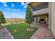 Backyard featuring artificial grass, professional landscaping, and a covered patio with access to indoor living space at 12415 Notch Trail Ave, Las Vegas, NV 89138