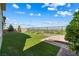 Lush backyard featuring artificial turf, mature trees, and manicured shrubbery bordered by an iron fence with mountain views at 12415 Notch Trail Ave, Las Vegas, NV 89138