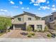 Two-story home featuring desert landscaping, a two-car garage, and a stylish exterior at 12415 Notch Trail Ave, Las Vegas, NV 89138