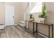 Bright foyer with wood floors, a staircase, and a stylish console table with plants at 12415 Notch Trail Ave, Las Vegas, NV 89138