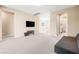 Spacious living room with neutral carpet, tv, and staircase access at 12415 Notch Trail Ave, Las Vegas, NV 89138