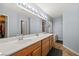 Bathroom with double sinks, large mirror, and walk-in closet at 231 Bristle Cone, Pahrump, NV 89048