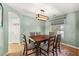 Dining room with a wooden table, six chairs, and a stylish light fixture at 231 Bristle Cone, Pahrump, NV 89048