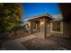 Inviting front entrance with stone pillars, custom door, and desert landscaping at twilight at 231 Bristle Cone, Pahrump, NV 89048