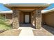 Inviting front porch with stone pillars and a white door, enhancing the curb appeal of the home at 231 Bristle Cone, Pahrump, NV 89048