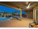 Covered patio with an outdoor ceiling fan with view of a tranquil pool and waterfall feature at 231 Bristle Cone, Pahrump, NV 89048