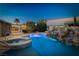 Gorgeous backyard pool with a rock waterfall feature and spa, creating a serene retreat at 231 Bristle Cone, Pahrump, NV 89048