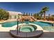 Beautiful backyard pool and spa with rock waterfall, surrounded by mature palm trees and lush greenery at 231 Bristle Cone, Pahrump, NV 89048
