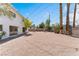 A spacious backyard featuring a white home with large windows, tall trees, and minimal plants at 2724 Natalie Ave, Las Vegas, NV 89121