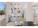 White kitchen with breakfast bar, modern pendant lights, and stainless steel appliances and light colored floor at 2724 Natalie Ave, Las Vegas, NV 89121