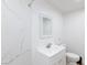 Bathroom showcasing white marble tiles, a white sink, toilet, and a glass shower at 335 W Basic Rd, Henderson, NV 89015