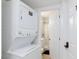Washer and dryer combo leads to a bathroom with marble and tile flooring at 335 W Basic Rd, Henderson, NV 89015