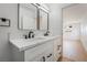 Contemporary bathroom with double sinks, white cabinets, and black hardware, open to the bedroom at 343 W Basic Rd, Henderson, NV 89015