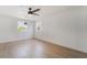 Minimalist bedroom featuring a ceiling fan, light wood floors, and a view of the neighborhood at 343 W Basic Rd, Henderson, NV 89015