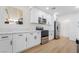 Modern kitchen boasts stainless steel appliances, white cabinetry, and light wood flooring at 343 W Basic Rd, Henderson, NV 89015