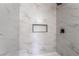 The shower has white and gray marble-look tiles, a built-in niche, and matte black fixtures at 343 W Basic Rd, Henderson, NV 89015