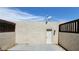 Enclosed backyard area with a door, stucco wall, brick accents, and a concrete patio at 3453 Del Marino Dr, Las Vegas, NV 89121