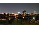 Nighttime view of neighborhood rooftops, palm trees, city buildings and Stratosphere in distance at 3453 Del Marino Dr, Las Vegas, NV 89121