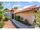 Exterior view of the home's entrance with a modern front door surrounded by mature landscaping and a stone walkway at 3629 Laguna Verde Way, Las Vegas, NV 89121