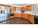 Updated kitchen with wood cabinets, stainless steel appliances, and hardwood floors at 3629 Laguna Verde Way, Las Vegas, NV 89121