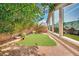 Landscaped backyard with artificial turf, desert plants, and mature shade trees at 3741 Via Gaetano, Henderson, NV 89052