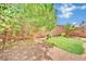 Private backyard with mature trees, green grass patch, and low-maintenance desert landscaping at 3741 Via Gaetano, Henderson, NV 89052