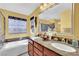 Bright bathroom with double sinks, soaking tub, and vanity with marble countertops at 3741 Via Gaetano, Henderson, NV 89052
