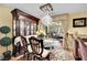 Elegant dining room with glass table, decorative china cabinet, chandelier, and neutral-toned walls at 3741 Via Gaetano, Henderson, NV 89052