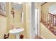 Charming powder room with pedestal sink, decorative mirror, and easy access to the stairs at 3741 Via Gaetano, Henderson, NV 89052