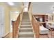 Carpeted staircase with wood railing leading to the upper level, laundry and living area views at 3741 Via Gaetano, Henderson, NV 89052