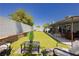 Backyard with artificial grass, a covered patio, and comfortable outdoor seating at 4492 Rita Dr, Las Vegas, NV 89121