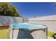 Above-ground pool in backyard with synthetic grass and a privacy wall, perfect for summer fun at 4492 Rita Dr, Las Vegas, NV 89121