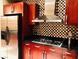 Gourmet kitchen featuring stainless steel appliances, cherry cabinets, and a decorative backsplash at 4575 Dean Martin Dr # 303, Las Vegas, NV 89103