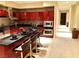 Open kitchen with breakfast bar, cherry cabinetry, and stainless steel appliances at 4575 Dean Martin Dr # 303, Las Vegas, NV 89103