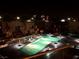 Night view of community pool with palm trees and illuminated townhouse units at 4575 Dean Martin Dr # 303, Las Vegas, NV 89103