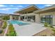 Back exterior showcasing a pool, spa, outdoor kitchen, and sliding glass doors to the main living space at 49 Crested Cloud Way, Las Vegas, NV 89135