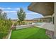 An inviting backyard features a pool, covered patio, an artificial lawn and desert landscaping, and mountain views at 49 Crested Cloud Way, Las Vegas, NV 89135