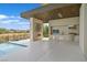 This stylish outdoor kitchen has modern stainless steel appliances, stone accents, and is adjacent to the pool at 49 Crested Cloud Way, Las Vegas, NV 89135