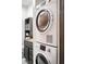 Stackable washer and dryer in bathroom with dark shaker cabinets at 4955 Jeffreys St # 605, Las Vegas, NV 89119