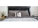 Close up of a queen sized bed with a decorative pillow and black and grey upholstered headboard at 4955 Jeffreys St # 605, Las Vegas, NV 89119