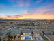 Expansive aerial view of a neighborhood showcasing the community's layout and mountain views under a sunset at 5081 Notting Hill Ave, Las Vegas, NV 89139