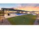 Beautiful backyard with a pool, bar, outdoor kitchen, and putting green, offering endless entertainment possibilities at 5081 Notting Hill Ave, Las Vegas, NV 89139