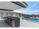 Outdoor kitchen with grill, pool, spa, dining, and seating areas create the perfect space for entertaining at 5081 Notting Hill Ave, Las Vegas, NV 89139