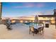 A spacious backyard with a large pool, outdoor kitchen, dining area, and plenty of seating for relaxing and entertaining at 5081 Notting Hill Ave, Las Vegas, NV 89139