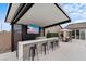 Stylish outdoor bar featuring a large TV, built-in grill, seating, and ample counter space for entertaining at 5081 Notting Hill Ave, Las Vegas, NV 89139