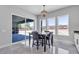 Bright dining area with a view of the backyard, modern chandelier, tile floors, and neutral color scheme at 6235 N Fort Apache Rd, Las Vegas, NV 89149