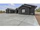Striking black exterior with a large driveway, featuring a modern and elegant design at 6235 N Fort Apache Rd, Las Vegas, NV 89149