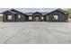 Stunning single-story home featuring a sleek black exterior and a spacious concrete driveway at 6235 N Fort Apache Rd, Las Vegas, NV 89149
