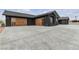 Stylish black exterior home with custom garage doors, set in a spacious and well-maintained yard at 6235 N Fort Apache Rd, Las Vegas, NV 89149