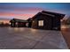 Dramatic black exterior home at sunset, highlighting its modern architectural design at 6235 N Fort Apache Rd, Las Vegas, NV 89149